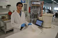 El jove investigador Oriol Cusola, del grup de recerca CelBiotech de la UPC, aplicant la nova substància, amb un esprai, a un material de base cel·lulòsica. 